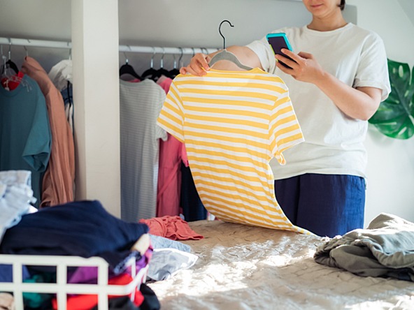 woman taking photograph of clothing to donate to charity or selling